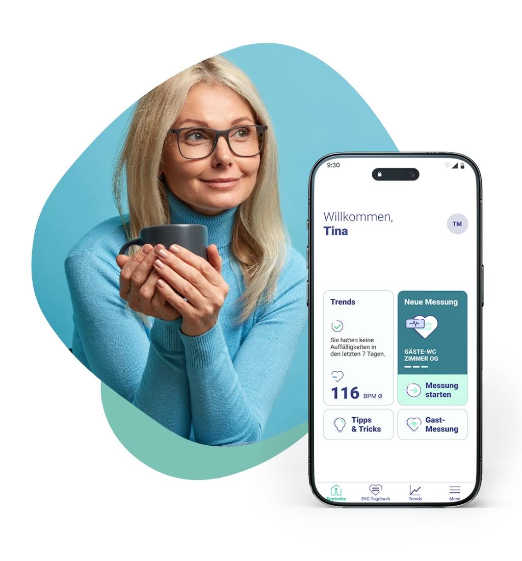 Eine Frau mittleren Alters mit langen blonden Haaren lächelt verschmitzt zur Seite, während Sie in beiden Händen vor sich eine Kaffeetasse hält. Im Vordergrund ist ein Smartphone zu sehen, auf welchem der Übersichtsbildschirm in der EKG-seat-App zu sehen ist.