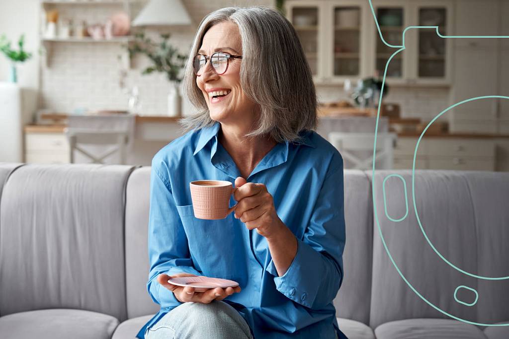 Lachende Frau sitzt mit einer Tasse in der Hand auf dem Sofa in einer Wohnung, daneben eine stilisierte Toilettengrafik des EKG-seats.