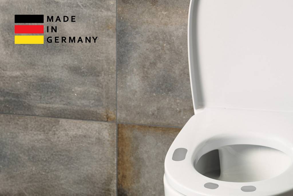 Teilansicht des EKG-seats mit Sensorflächen vor einer grau strukturierten Fliesenwand, links oben ein „Made in Germany“-Logo mit Deutschlandflagge.